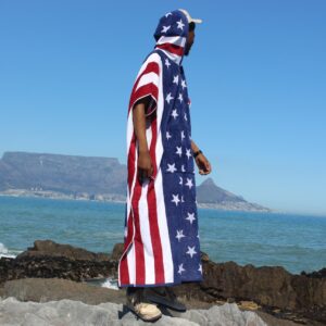 Man at beach in a poncho.