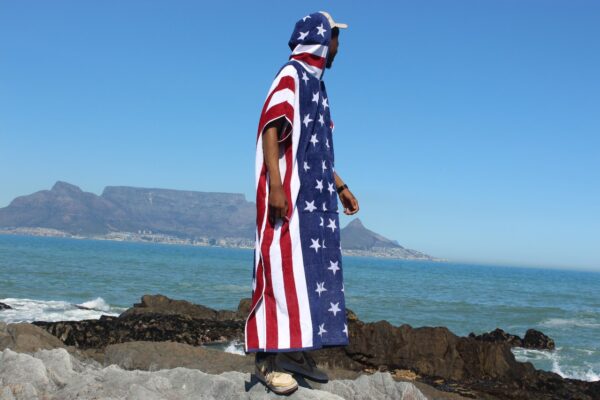 Man at beach in a poncho.